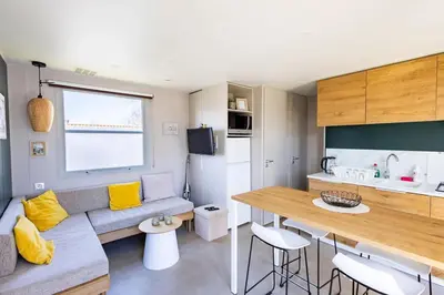 a kitchen and living room with a couch and a table at Camping Papillon Kinrooi - Vakantiehuis Familie 6P in Kinrooi