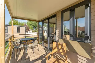 a patio with a table and chairs on a porch at Camping Papillon Kinrooi - Vakantiehuis Premium 4P in Kinrooi