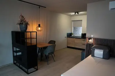 a living room with a table and a kitchen at Camping Natuurlijk Limburg - Studio 1 in Voeren