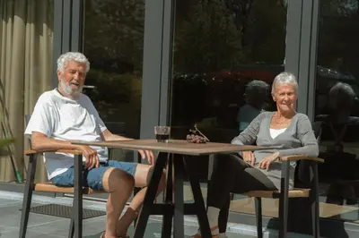 an older man and woman sitting at a table at Camping Natuurlijk Limburg - Studio 1 in Voeren
