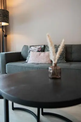a living room with a couch and a table at Camping Natuurlijk Limburg - Studio 1 in Voeren