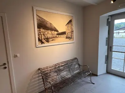 a bench in a room with a picture on the wall at L'Orée des Thermes in Chaudfontaine