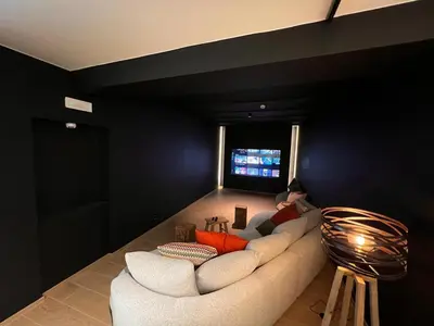 a living room with a white couch and a black wall at L'Orée des Thermes in Chaudfontaine