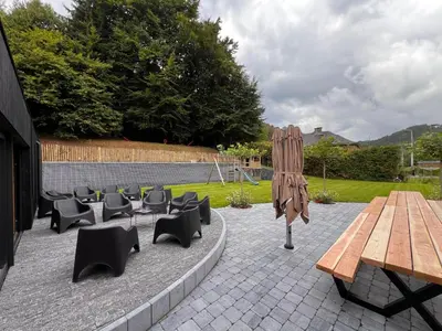 a patio with a wooden table and chairs at L'Orée des Thermes in Chaudfontaine