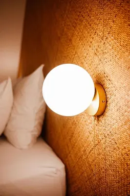 a light on the side of a bed with pillows at Héritage Collection - Suites in Verviers