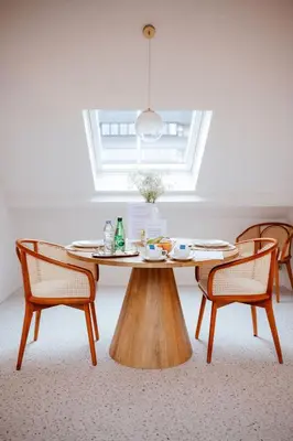 a wooden table with two chairs and a window at Héritage Collection - Suites in Verviers