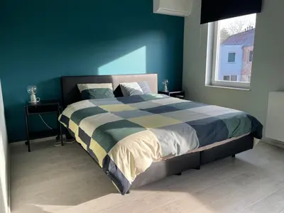 a bedroom with a large bed with a blue wall at JoHa Haus in Hasselt