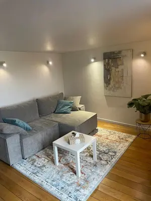 a living room with a couch and a table at Le Havre de paix in Oupeye