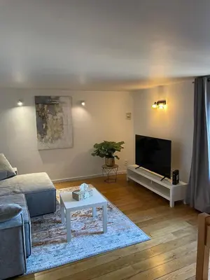 a living room with a couch and a flat screen tv at Le Havre de paix in Oupeye