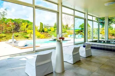 a room with a table and chairs and a large window at Villa Bianca in Dalhem