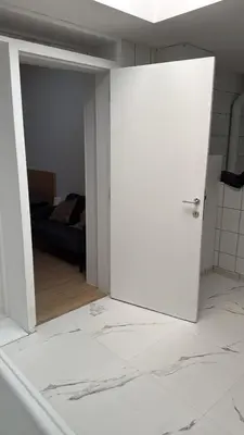 a white door in a room with a bedroom at Studio Cosy rénové au Centre de Liège in Liège