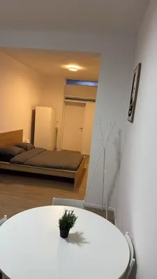 a room with a white table and a bed at Studio Cosy rénové au Centre de Liège in Liège
