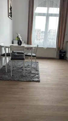 a white table and chairs in a room with a window at Studio Cosy rénové au Centre de Liège in Liège