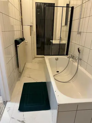 a bathroom with a bath tub with a green mat at 1 Chambre et Sofa Bed en plein cœur de Liege in Liège