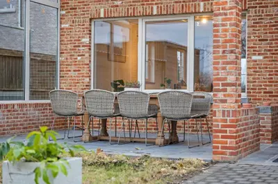 a group of chairs sitting around a table in front of a window at Ruime vakantievilla in Halen voor 12 personen in Halen