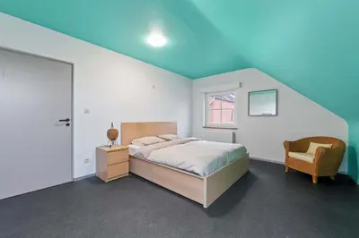 a bedroom with a bed and a chair at Ruime vakantievilla in Halen voor 12 personen in Halen