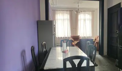 a table and chairs in a room with a kitchen at Appartement 2 chambre Liege in Liège