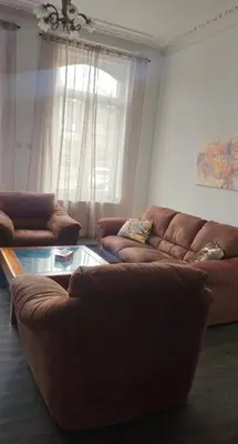 a living room with two couches and a glass table at Appartement 2 chambre Liege in Liège