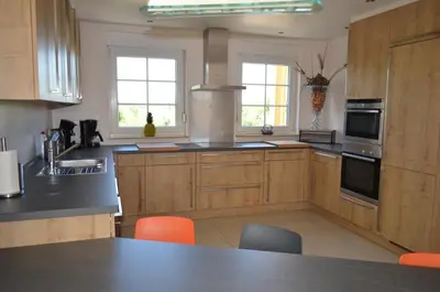 a kitchen with wooden cabinets and a black counter top at Holiday Home Mooi - Voeren in Voeren
