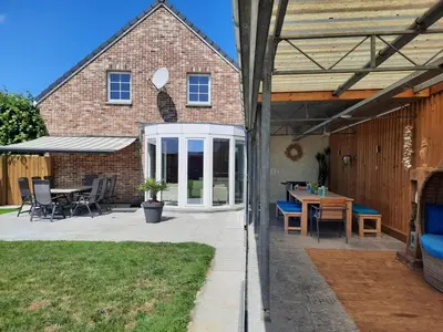 a patio with a table and chairs and a house at Holiday Home Mooi - Voeren in Voeren