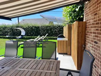 a patio with a wooden table and chairs at Holiday Home Mooi - Voeren in Voeren