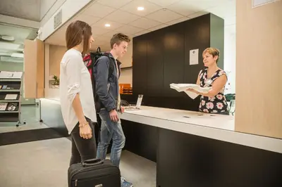 a group of people standing at a counter at Hostel H in Hasselt