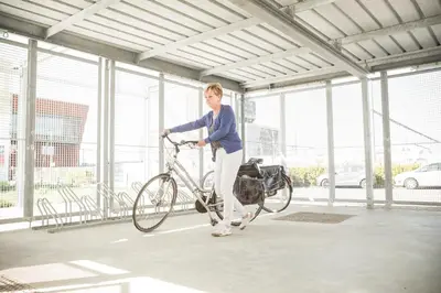 a woman is holding a bike in a building at Hostel H in Hasselt