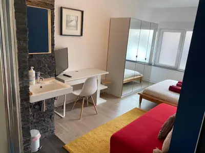a bathroom with a sink and a desk in a room at Studio Peralta in Liège
