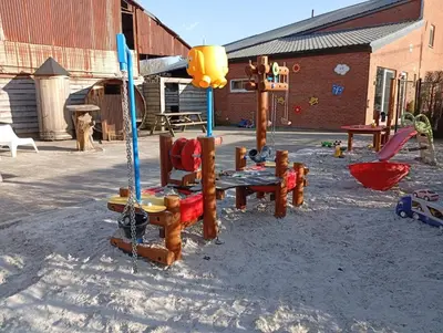 a playground with wooden play equipment in the snow at DE SMISHOEVE met kinderpret, dieren en wellness in Heers