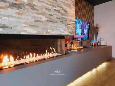a living room with a fireplace and a tv at La Suite in La Calamine