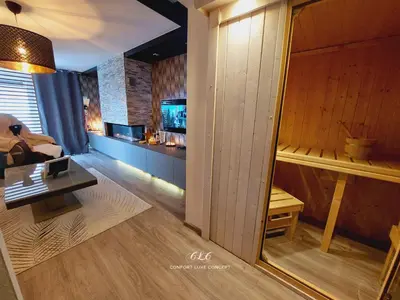 a room with a living room with a tv and a table at La Suite in La Calamine