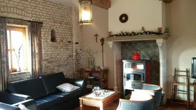 a living room with a couch and a fireplace at Vakantiewoning Venderhof in Maaseik