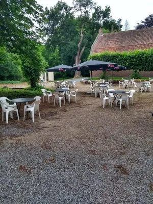a group of tables and chairs with umbrellas at Domein Hengelhoef in Houthalen-Helchteren