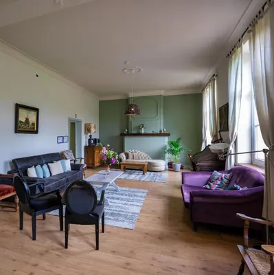 a living room with purple furniture and green walls at Kasteel Nieuwenhoven in Sint-Truiden