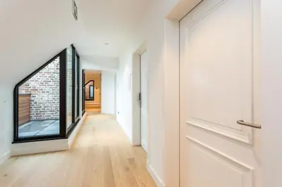 a hallway with a door and a brick wall at De Sjeiven Dorpel in Maaseik