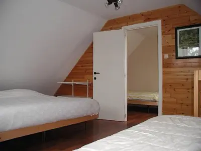a bedroom with two beds and a door to a closet at De Bosbeekpoort in Oudsbergen
