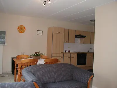 a kitchen with a couch and a table with chairs at De Bosbeekpoort in Oudsbergen