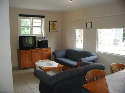 a living room with a couch and a tv at De Bosbeekpoort in Oudsbergen