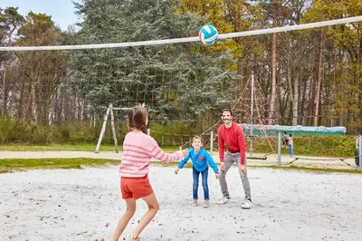 a man and a child playing with a volley ball at Green Resort Limburg in Houthalen-Helchteren