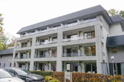 an apartment building with cars parked in front of it at Green Resort Limburg in Houthalen-Helchteren