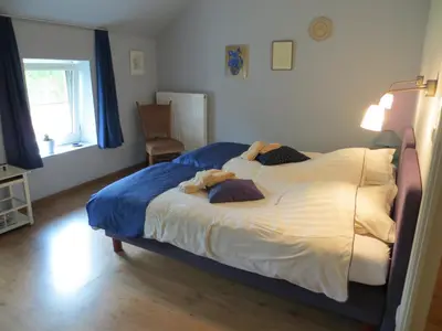 a bedroom with a large bed in a room with a window at De Aventurijn in Riemst