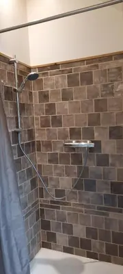 a shower with a hose attached to a brick wall at De Blauwe Maaten in Neerglabbeek