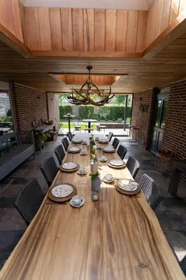 a long wooden table with chairs and a chandelier at Tussen Hemel en Maas in Dilsen-Stokkem