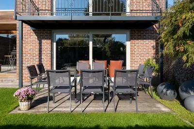 a group of chairs and a table on a patio at Tussen Hemel en Maas in Dilsen-Stokkem