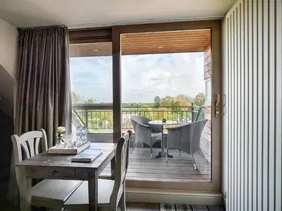 a dining room with a table and a sliding glass door at Tussen Hemel en Maas in Dilsen-Stokkem