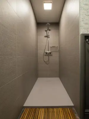 a bathroom with a shower with a tile wall at Tussen Hemel en Maas in Dilsen-Stokkem