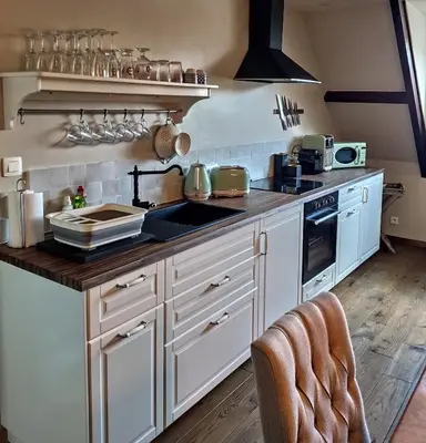 a kitchen with white cabinets and a sink and a stove at Het Hemelsveld in Hasselt
