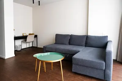a living room with a blue couch and a table at Porta Cité in Maasmechelen