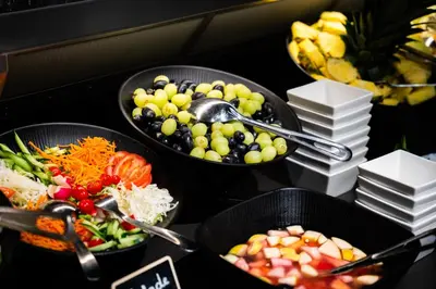 a buffet with three bowls of food on a table at Porta Cité in Maasmechelen