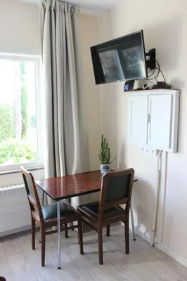 a dining room table with two chairs and a window at Villa Kakelbont Borgloon in Borgloon